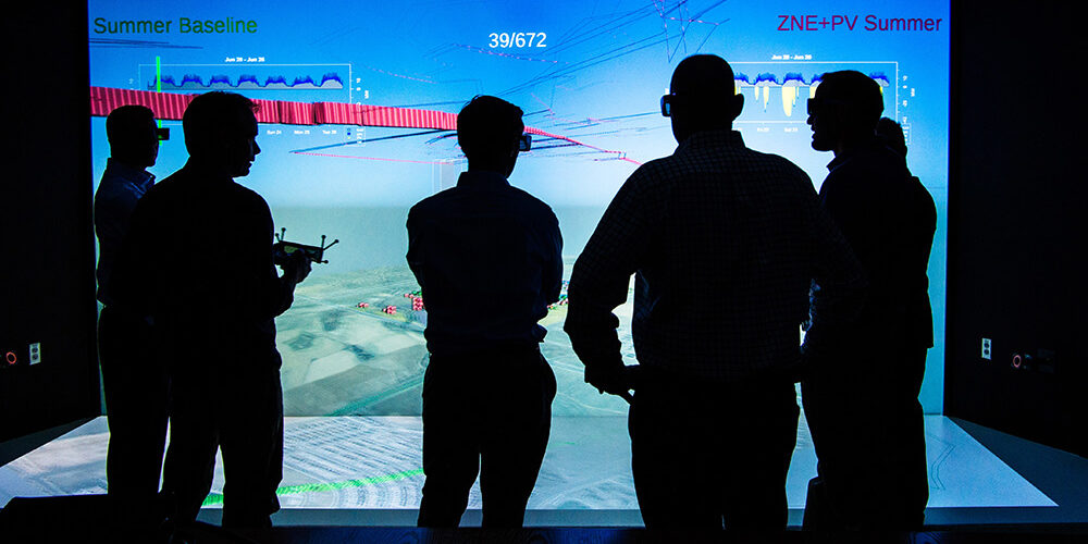 People standing in front of a large screen