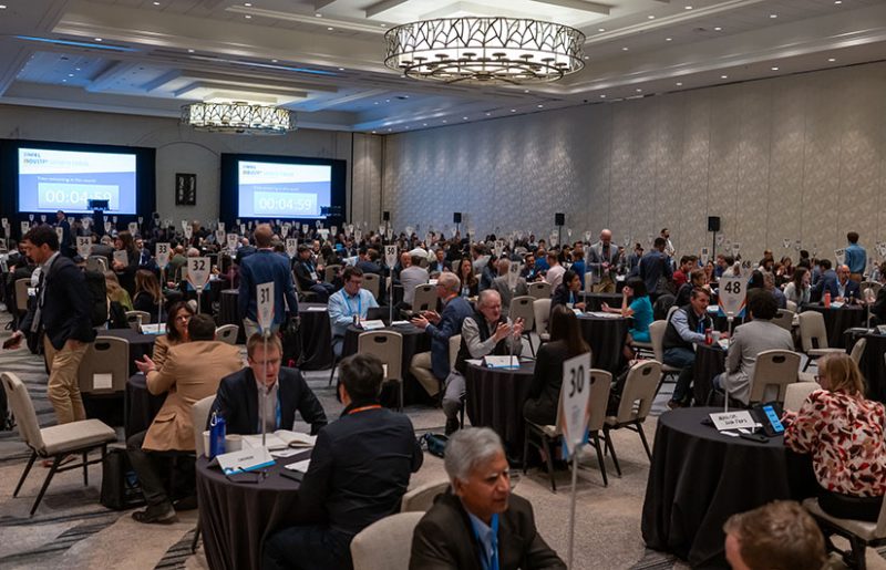 IGF-2025 Hundreds of people sit at small tables in one-on-one meetings in a large ballroom.
