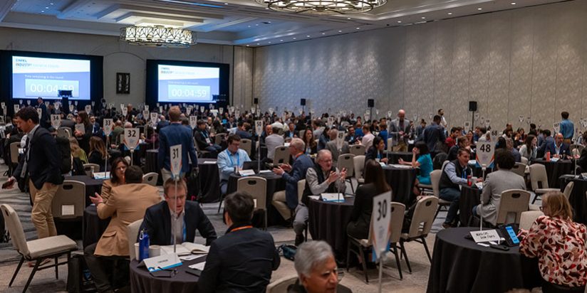 IGF-2025 Hundreds of people sit at small tables in one-on-one meetings in a large ballroom.